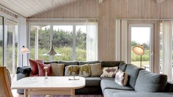 A cozy living room with a grey sofa, a small table, and a patterned rug.