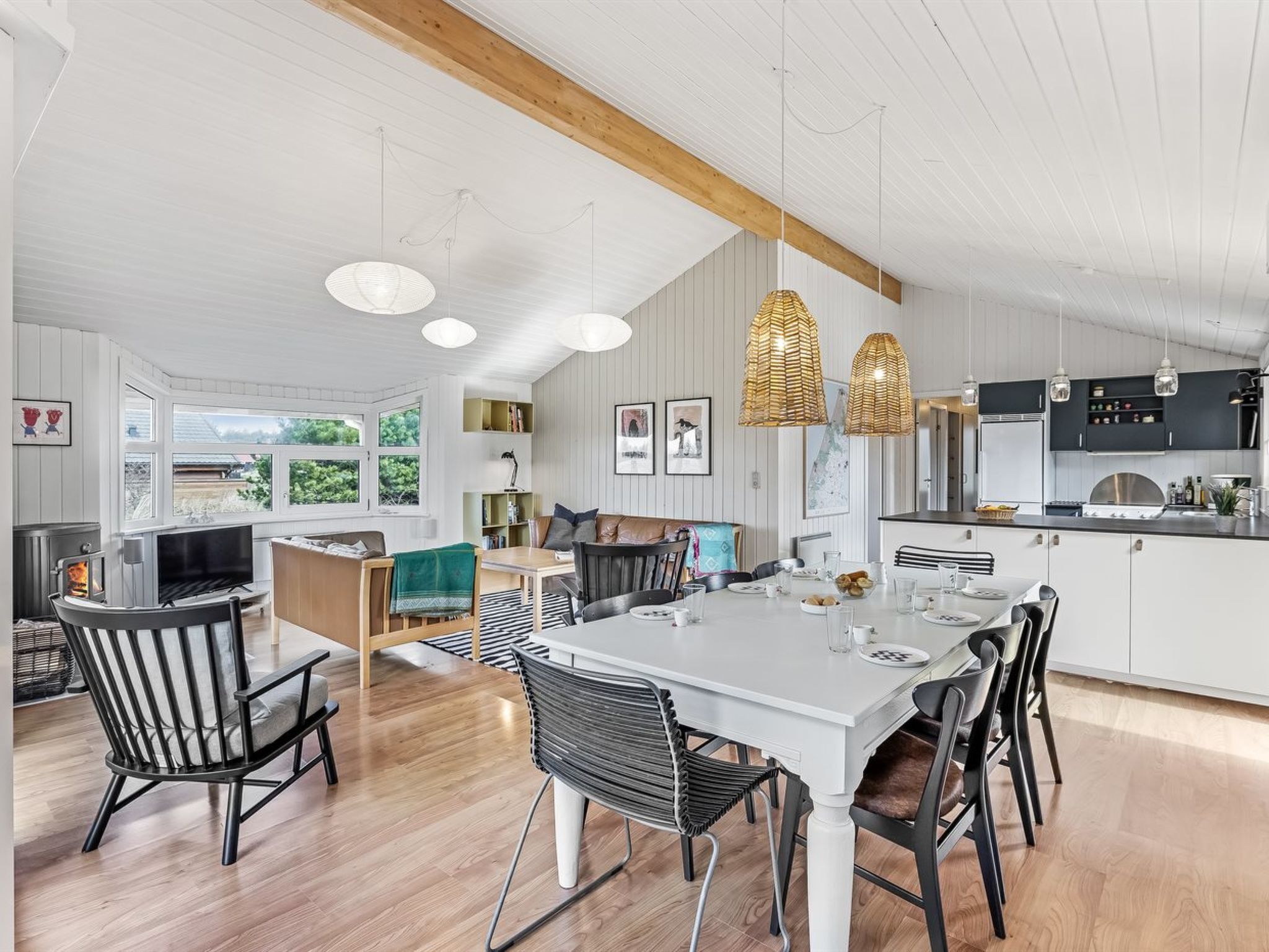 A modern kitchen with white cabinetry, a central island, and pendant lighting.