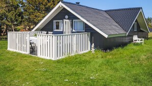 Une cabane de plain-pied dotée d’une terrasse clôturée, d’un petit porche et d’un toit en pente.