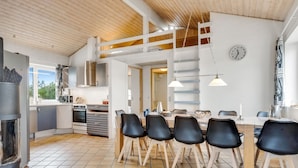 A modern kitchen with a dining area, wooden ceiling, and a clock on the wall. - "Palli" - 600m from the sea by Interhome (Thisted)