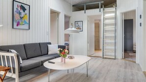 A modern living room with a grey sofa, a white coffee table, and a painting on the wall. - "Ibo" - 900m from the sea by Interhome (Thisted)