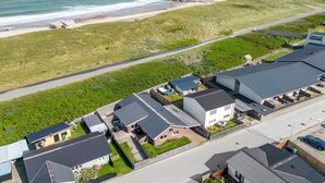 Oversigtsbillede af et kystnært boligområde med huse, en vej og en strand.