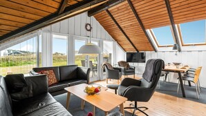 A spacious loft with a high ceiling, large windows, and a cozy seating area with a sofa and chairs. - "Olesia" - 250m from the sea by Interhome (Harboøre)