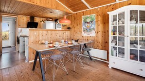 A wooden interior with a dining area, kitchen, and a cabinet with glass doors. - "Brigit" - 200m from the sea by Interhome (Harboøre)