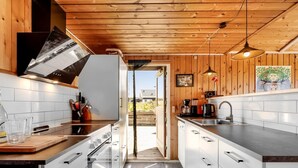 A modern kitchen with wooden walls, a stainless steel sink, and a view to the outside. - "Brigit" - 200m from the sea by Interhome (Harboøre)
