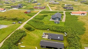 Vista aérea de una zona residencial con casas, caminos y campos verdes.