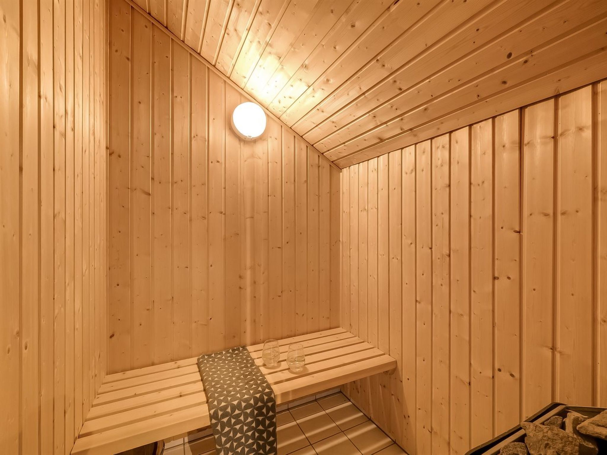 A sauna with wooden walls and a bench.