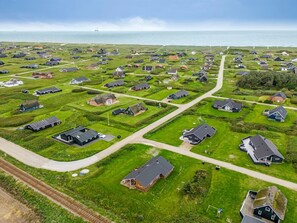 Vista aérea de una zona residencial con casas, calles y una vía ferroviaria.