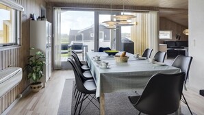 A modern dining area with a large table, black chairs, and pendant lighting. - "Hebba" - 300m from the sea by Interhome (Harboøre)