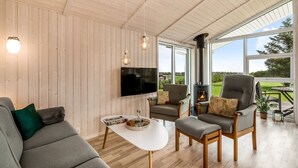 A cozy living room with a sofa, armchairs, a coffee table, and a fireplace. - "Tanna" - 330m to the fjord by Interhome (Lemvig)