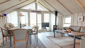 A cozy loft-style room with a dining area, a sofa, and a fireplace.