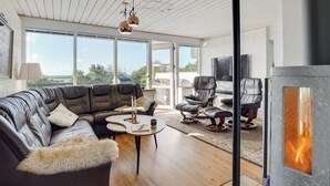 A modern living room with a large sectional sofa, a fireplace, and a view of the outdoors. - "Tomine" - 500m to the fjord by Interhome (Struer)