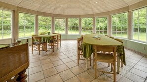 A sunroom with a high ceiling and large windows offering a view of the outdoors. - "Wilmar" - 1km to the fjord by Interhome (Vemb)