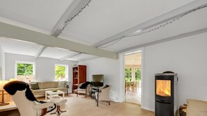 A modern living room with a fireplace, wooden flooring, and a large window. - "Wilmar" - 1km to the fjord by Interhome (Vemb)