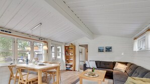 En rummelig stue med et træbord, en sofa og et sofabord.