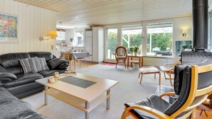 A spacious living area with a black leather sofa, a wooden coffee table, and a fireplace. - "Ulrike" - 600m to the fjord by Interhome (Ulfborg)
