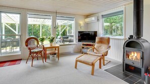 A cozy living room with a fireplace, large windows, and a TV. - "Ulrike" - 600m to the fjord by Interhome (Ulfborg)