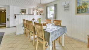 A dining area with a table set for four, wooden chairs, a hanging light fixture, and a painting on the wall. - "Elizabeth" - 400m to the fjord by Interhome (Ulfborg)