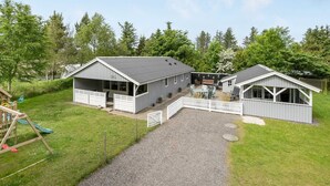 A two-story building with a covered patio area and a separate building with a sloped roof. - "Elizabeth" - 400m to the fjord by Interhome (Ulfborg)