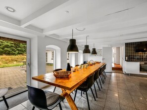 A modern dining area with a long wooden table, black chairs, and pendant lighting. - "Cornelius" - 900m from the sea by Interhome (Ulfborg)