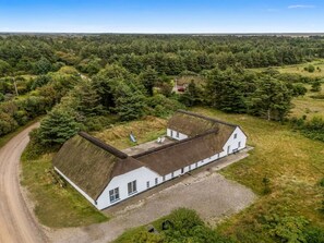 A white building with a thatched roof, surrounded by a gravel driveway and a dirt path. - "Cornelius" - 900m from the sea by Interhome (Ulfborg)