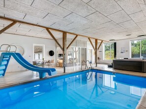 An indoor swimming pool with a slide, wooden beams, and a view of the outdoors. - "Cornelius" - 900m from the sea by Interhome (Ulfborg)