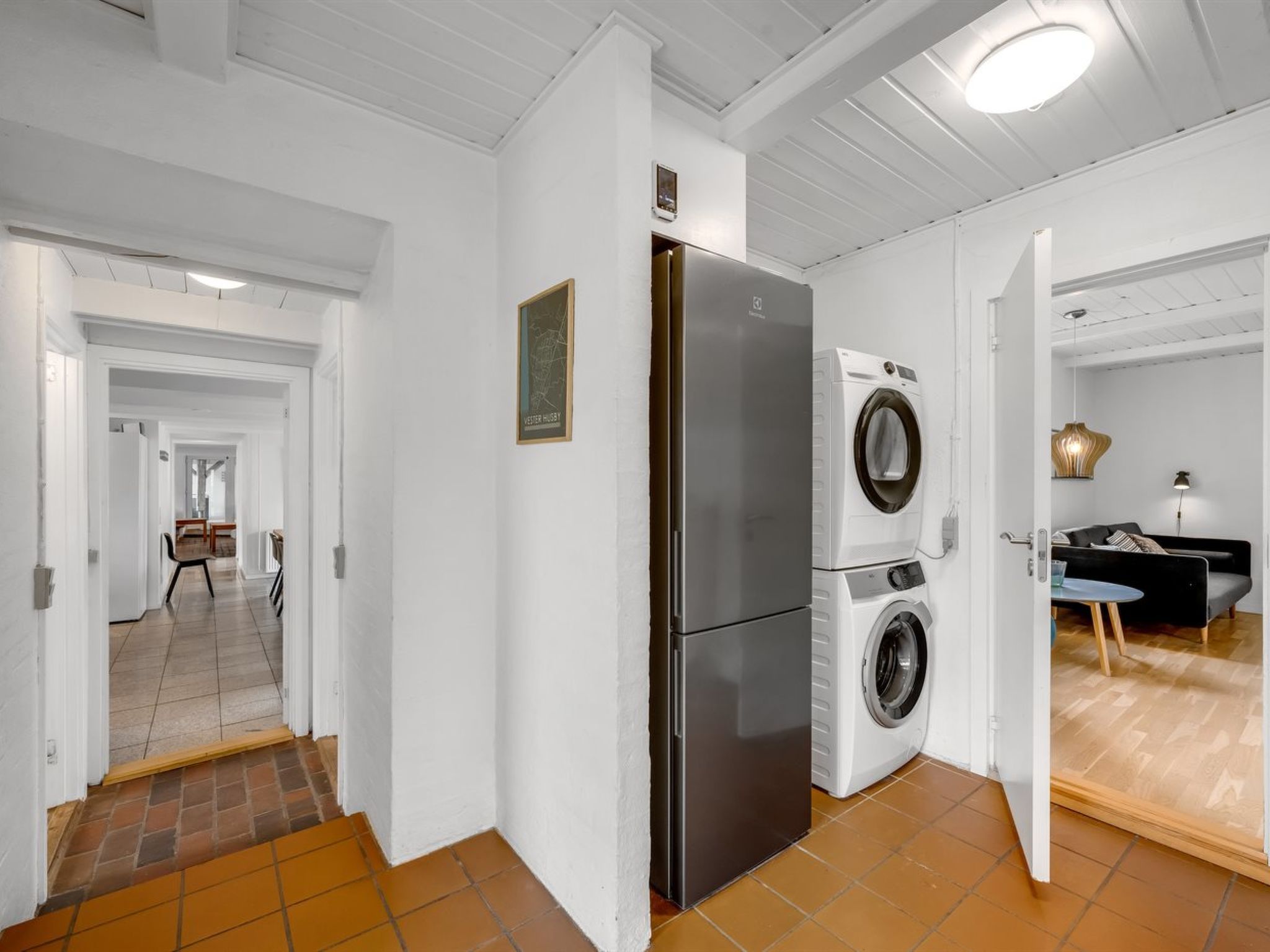 A modern kitchen with a stainless steel refrigerator and a front-loading washing machine.