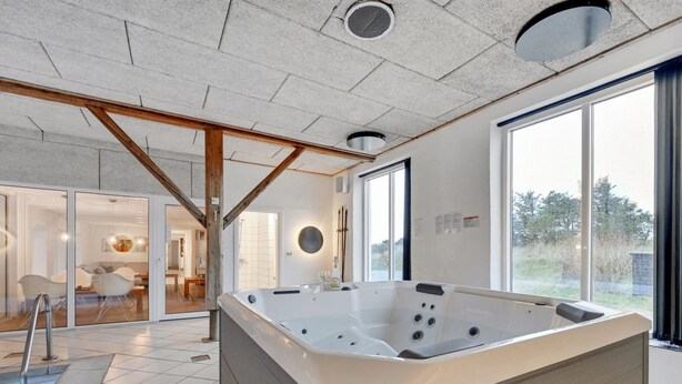 A modern bathroom with a large bathtub, a shower area, and a glass door leading to a living space. - "Cornelius" - 900m from the sea by Interhome (Ulfborg)