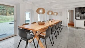 A modern dining area with a long wooden table, black chairs, and pendant lights. - "Cornelius" - 900m from the sea by Interhome (Ulfborg)