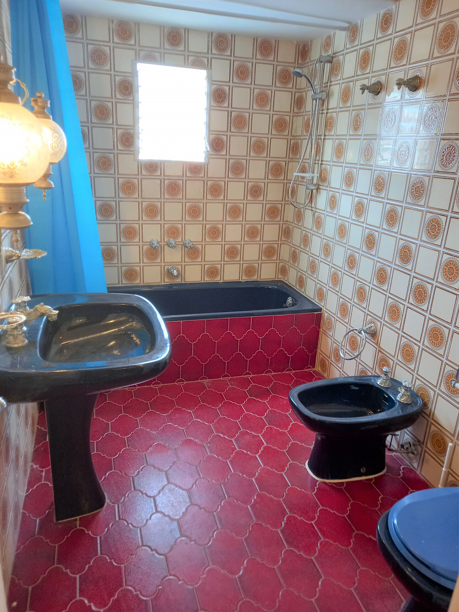 A bathroom with a black sink, a black toilet, and a bathtub.