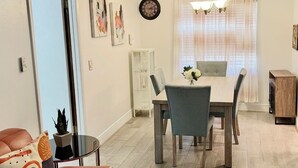 A modern living room with a dining area, a sofa, a coffee table, and a chandelier. - Elegant 3 Bedrooms with private pool, close to Disney World,Downtown Kissimmee. (Kissimmee)