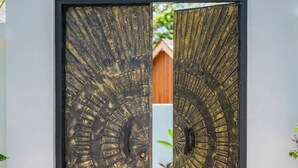 A modern entrance with a large, circular metal door. - Villa Arunika - 2BR Villa (Tabanan)