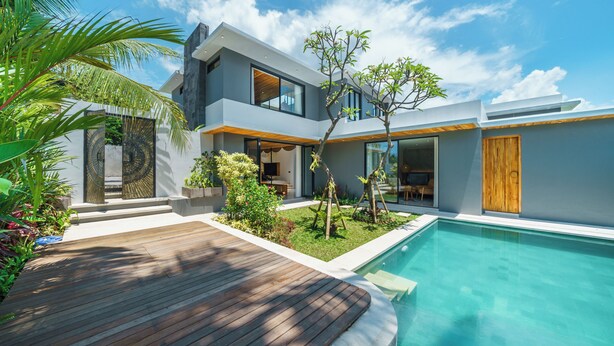 A modern house with a swimming pool, wooden deck, and a well-maintained garden. - Villa Arunika - 2BR Villa (Tabanan)