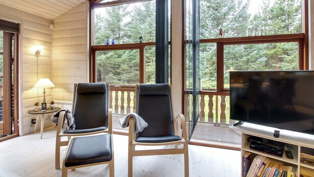 Una habitación acogedora con dos sillones, un televisor y una estantería.