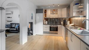Eine moderne Küche mit Einbauofen, Edelstahlgeräten und Holzboden.