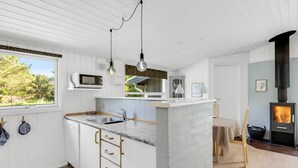 Una cucina moderna con mobili bianchi, un piano di lavoro in marmo e un piano cottura integrato.