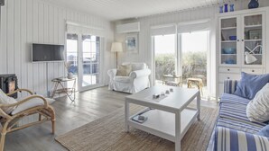 A spacious living room with a white sofa, a striped couch, a coffee table, and a fireplace. - "Adelita" - 100m from the sea by Interhome (Løkken)