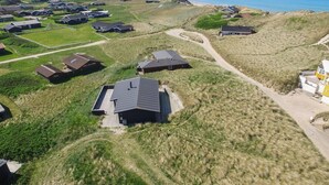 An aerial view of a coastal residential area with houses, a beach, and a lighthouse in the distance. - "Adelita" - 100m from the sea by Interhome (Løkken)