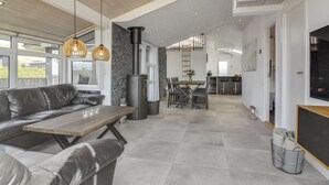 Ein modernes Wohnzimmer mit einer Couch, einem Esstisch und einem Kamin.