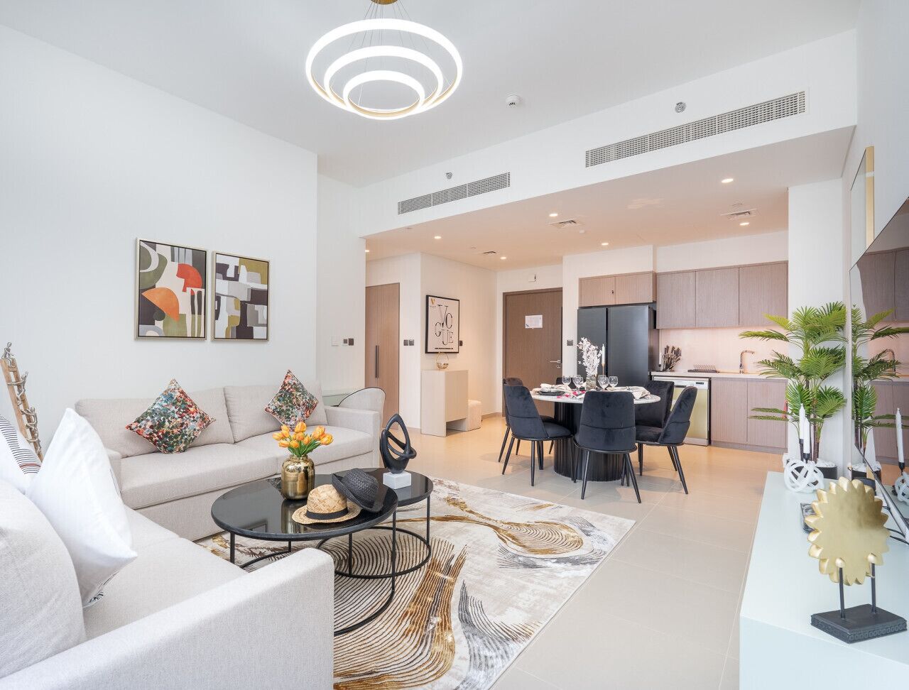 A modern living room with a sofa, coffee table, and dining area.