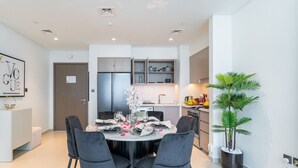 Un comedor moderno con una mesa redonda, sillas negras y un centro de mesa decorativo.