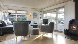 A modern living room with a fireplace, grey sofas, and a television.