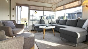 A modern living room with a grey sectional sofa, a round coffee table, and a grey armchair.
