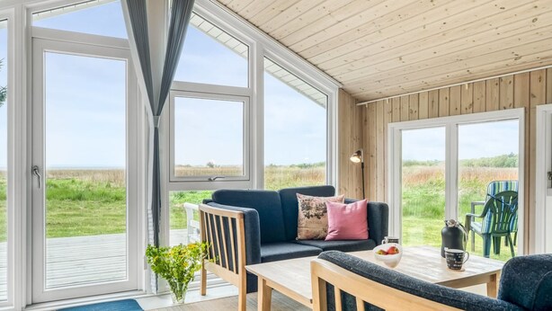 A spacious room with large windows, a wooden ceiling, and a view of the outdoors. - "Eske" - 200m to the fjord by Interhome (Aabybro)