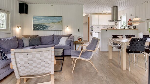 A modern, well-lit living area with a sofa, a woven chair, and a dining table with chairs. - "Tjordis" - 600m to the fjord by Interhome (Hvide Sande)
