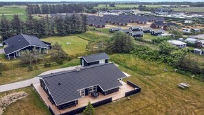 A modern residential area with multiple houses, each featuring a dark roof and a mix of wooden and concrete structures. - "Mayke" - 900m from the sea by Interhome (Løkken)