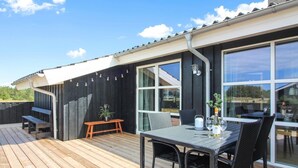 A deck with a table and chairs, a bench, and a potted plant. - "Mayke" - 900m from the sea by Interhome (Løkken)