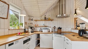 A modern kitchen with white cabinets, wooden countertops, a built-in oven, and a large window providing natural light. - "Stefani" - 1km from the sea by Interhome (Ebeltoft)