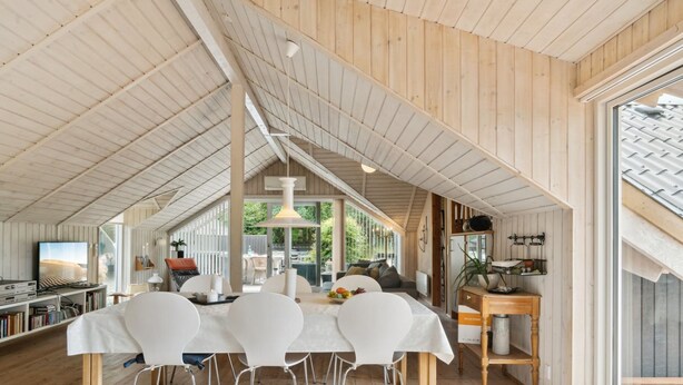 A spacious dining area with a high ceiling and wooden beams, a large window providing natural light, and a view of the outdoors. - "Stefani" - 1km from the sea by Interhome (Ebeltoft)