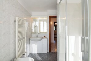 Een douche, een haardroger, een bidet, handdoeken